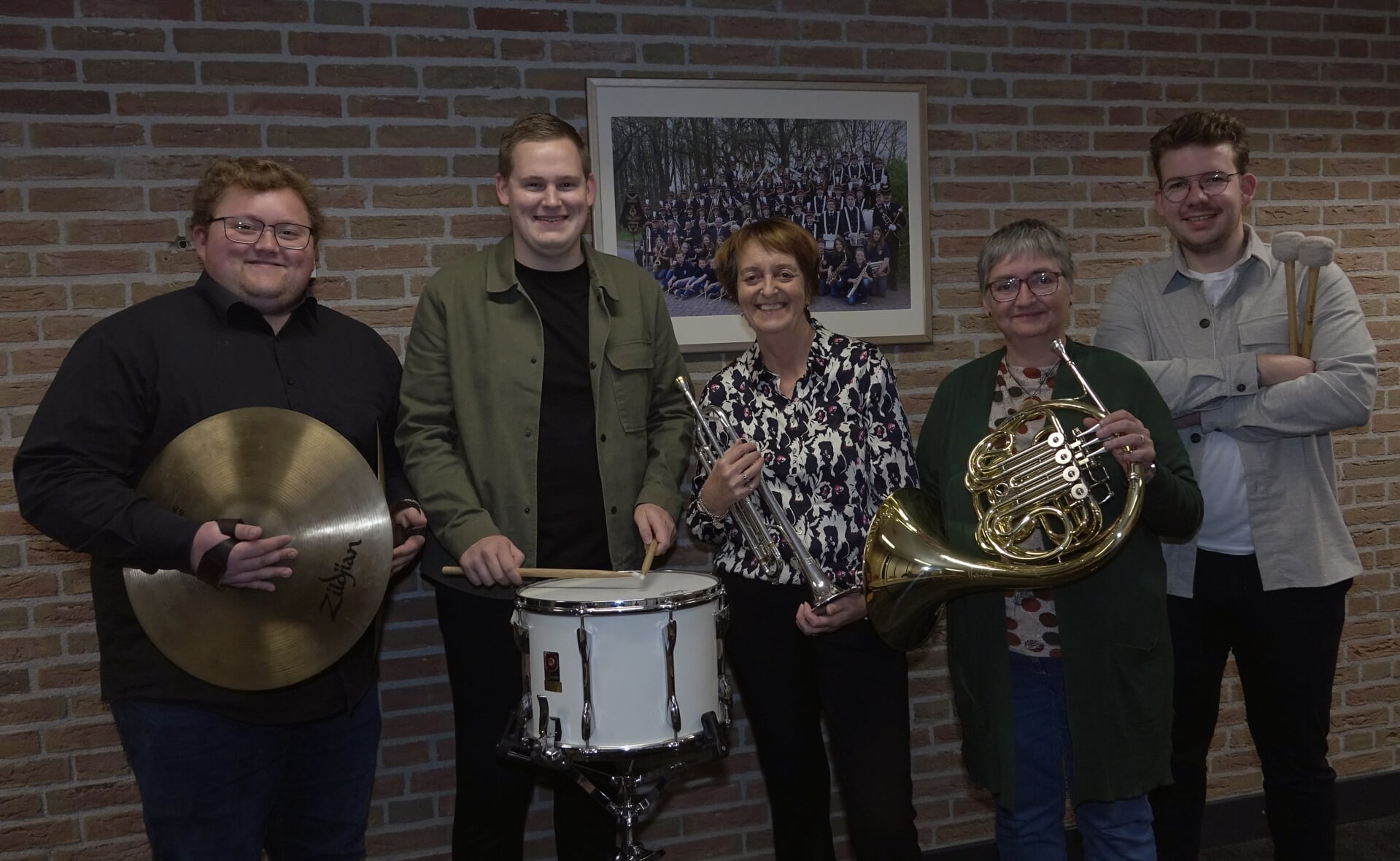 De gouden jubilarissen van fanfare Concordia, Henriëtte Smulders (trompet) en Miriam van den Boer (hoorn) worden geflankeerd door de slagwerkers Jari van Aarle, Jorn van den Heuvel en Tjeerd van Kollenburg die 12,5 jaar lid zijn. Juul van Engeland ontbreekt op de foto.