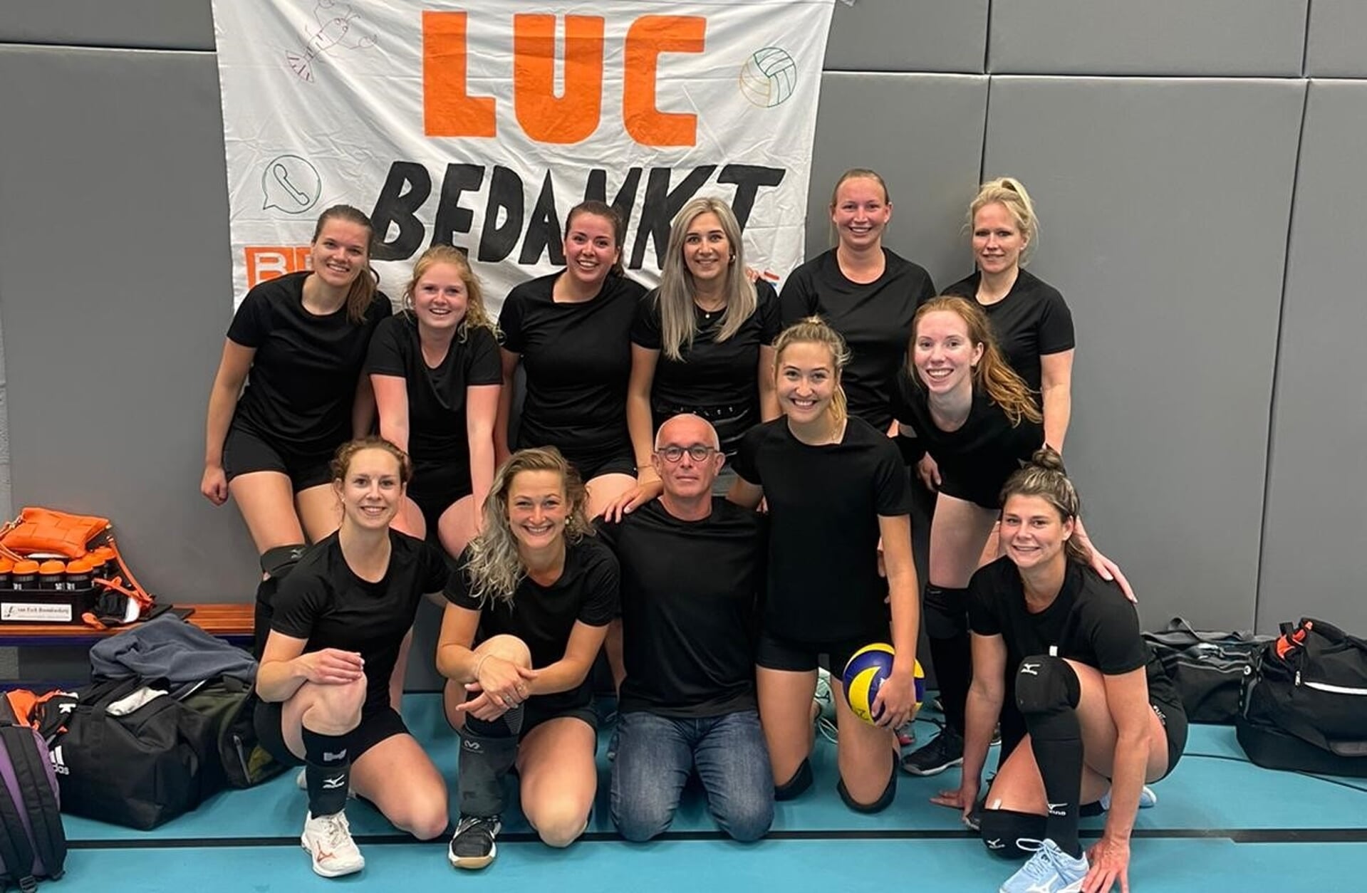 Trainer Luc Kivit (derde van linksonder) krijgt een afscheid in stijl van 'zijn' volleybalteam. De vrouwen van VC Blox wonnen de competitieafsluiting met 4-0 van Hajraa in Eindhoven.