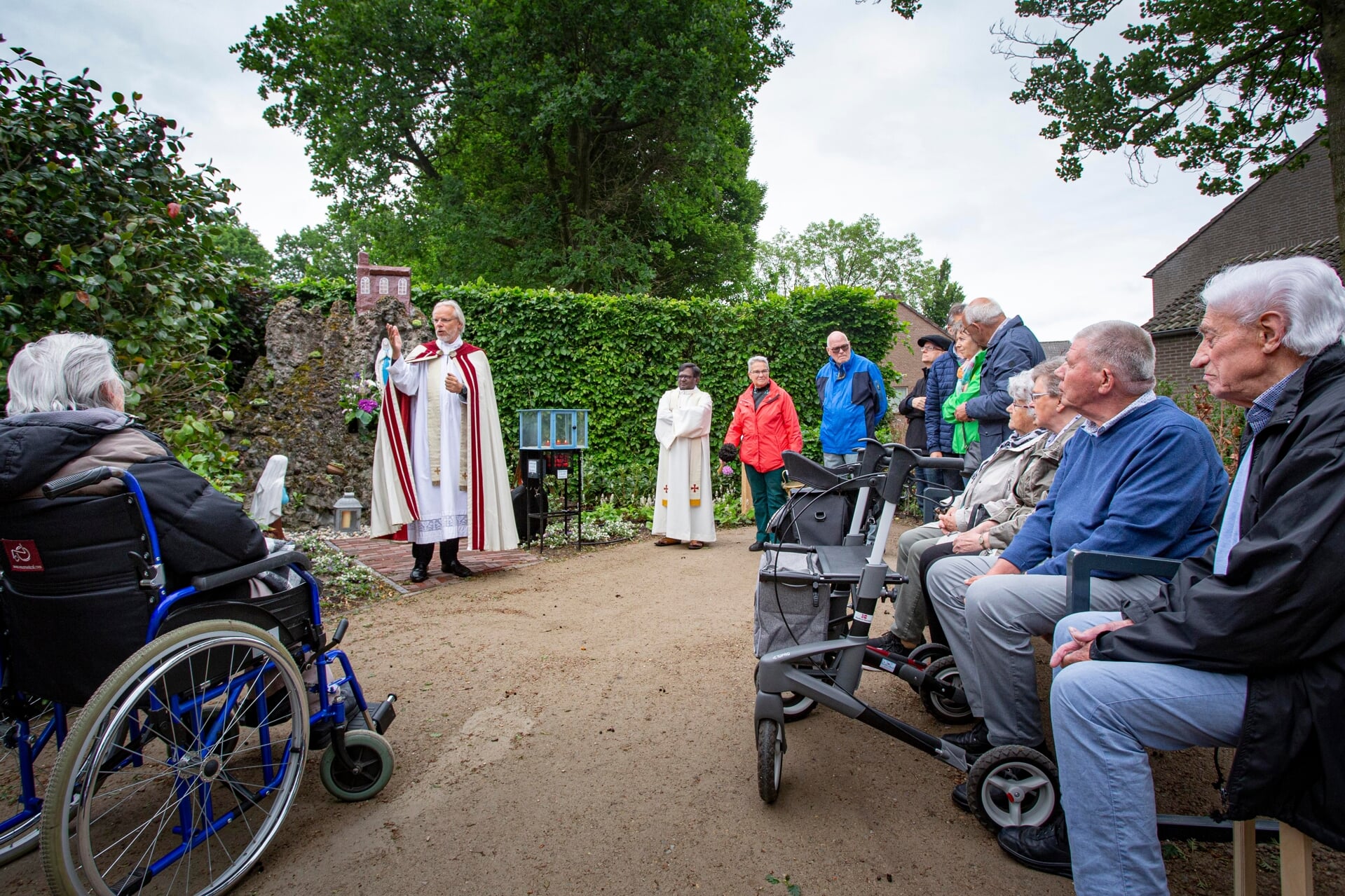 Pastoor Geertjan van Rossem geeft zijn zegen aan de gerestaureerde Lourdesgrot in de Liempdse kloostertuin.