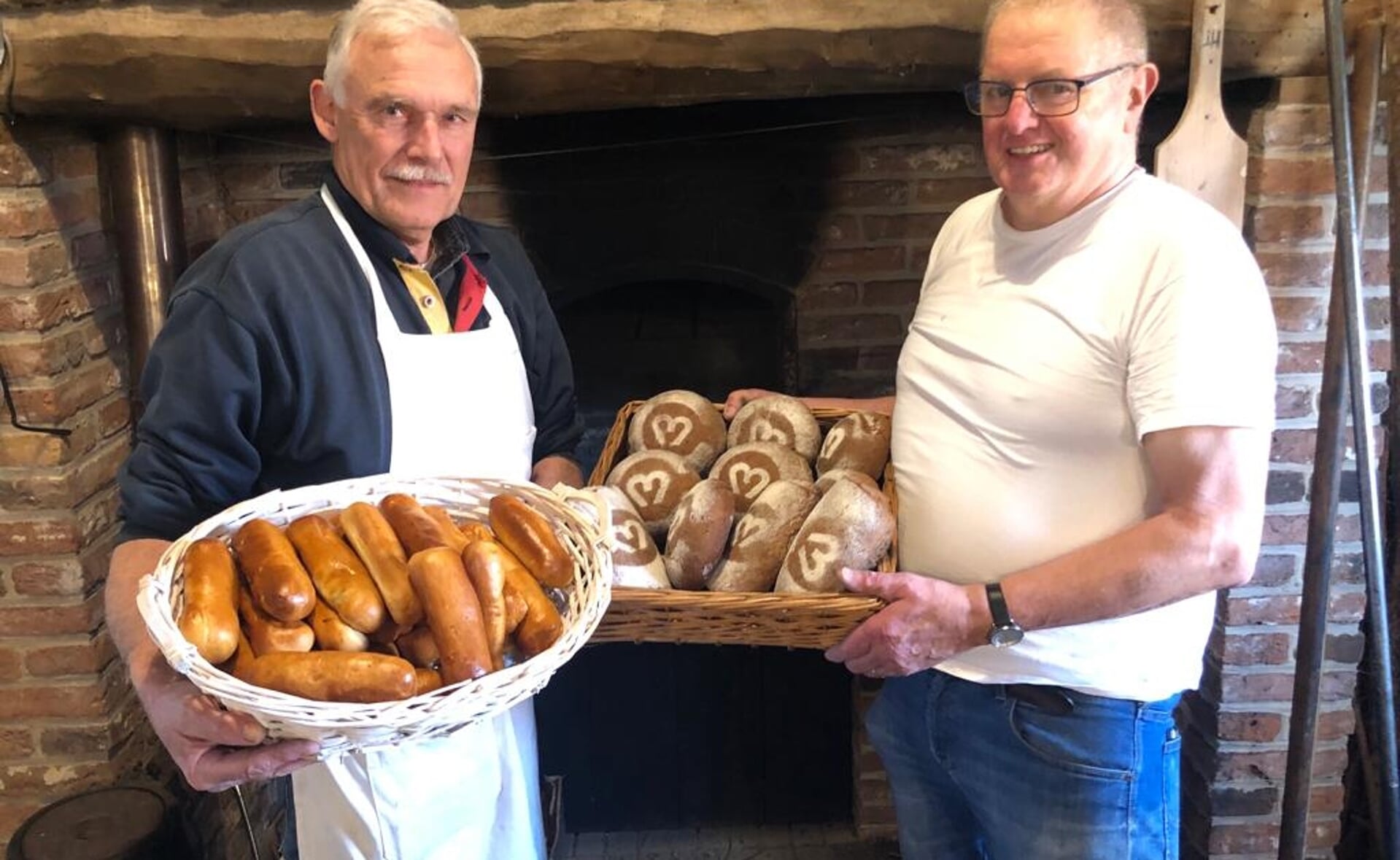 Twee leden van het hobbybakkersgilde in Liempde tonen enkele producten die elke tweede zondag van de maand uit de oven komen. 