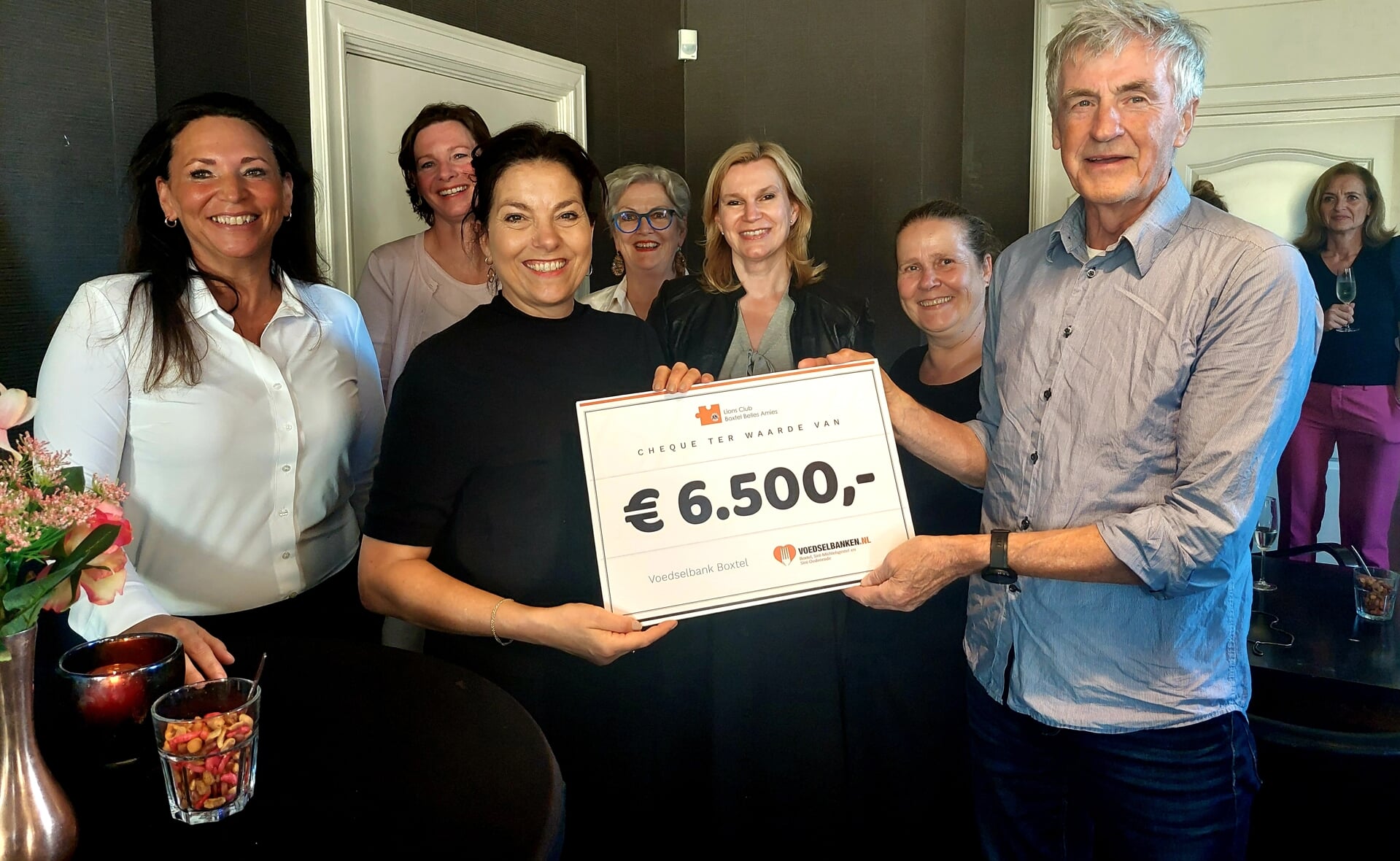 Vicevoorzitter Franks Hoeks van de Voedselbank Boxtel krijgt in restaurant De Rechter uit handen van oud-president Annemieke Beekmans van Lions Club Belles Amies de cheque uitgereikt. 