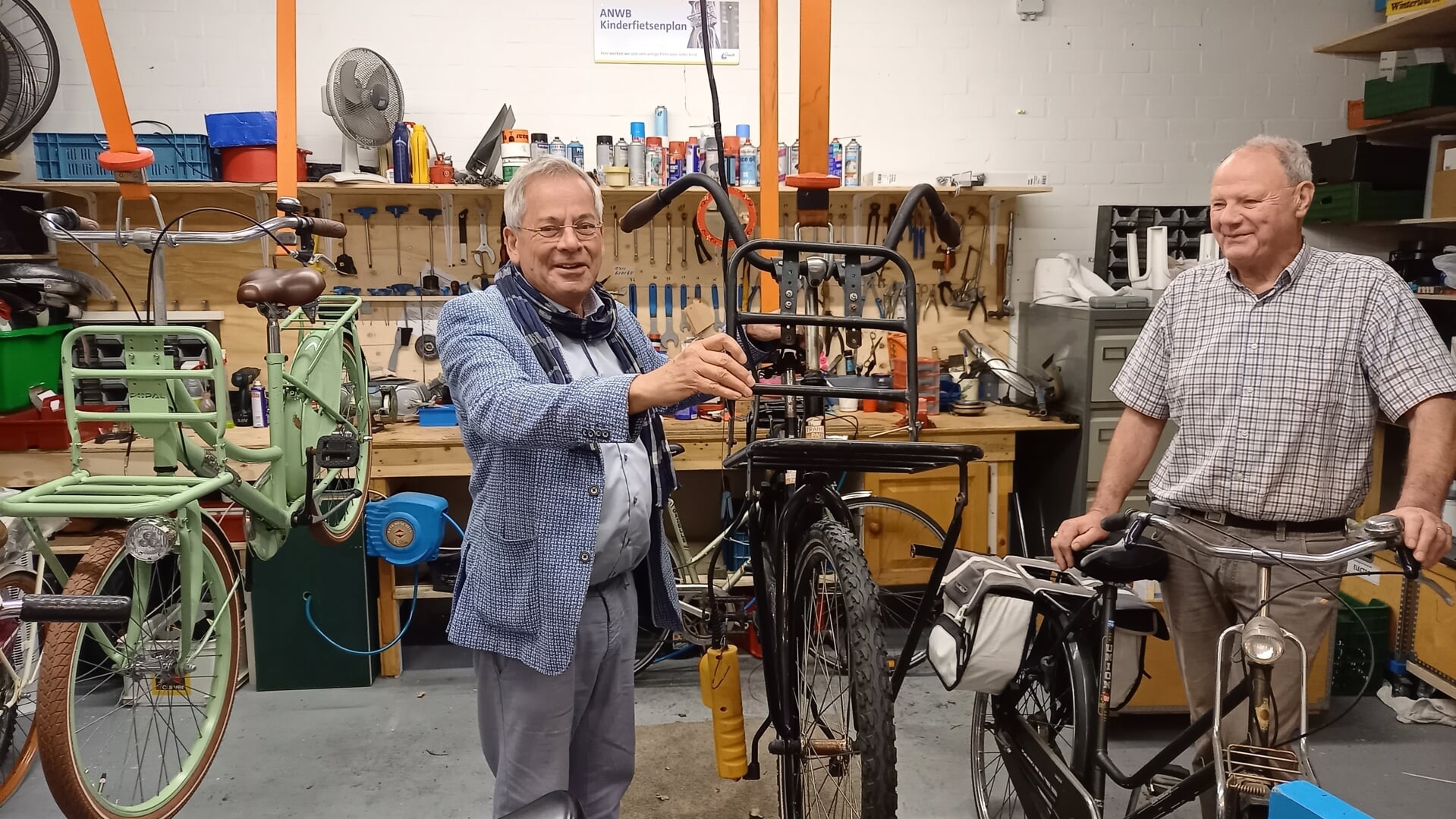 Voorzitter Arjen Witteveen van stichting Leergeld Boxtel en vicevoorzitter Tini van den Berg van de Vincentiusvereniging in de werkplaats waar gebruikte fietsen worden opgeknapt.