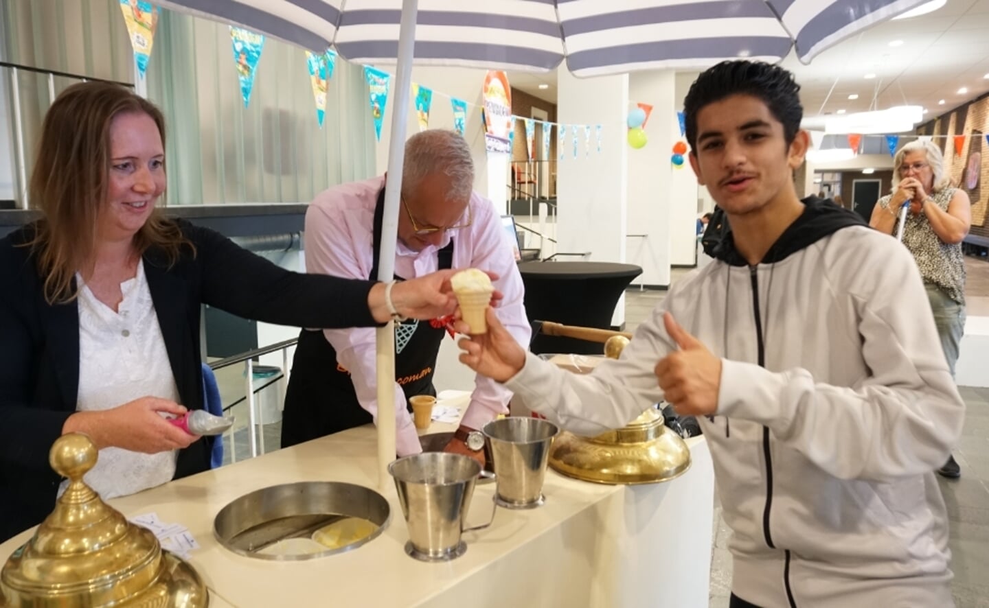 Shahab krijgt een ijsje van Van den Berg zijn directie-collega Mireille van der Kracht.