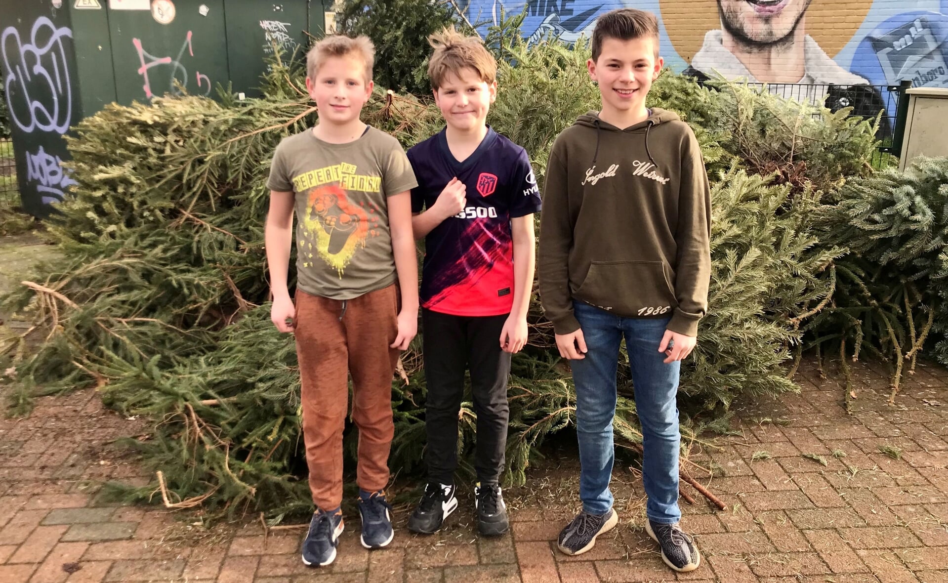 V.l.n.r.: Teun Dominicus, Figo van Steenhoudt-Carré en Pim van de Sande hebben heel wat kerstbomen ingezameld en naar het Breukelsplein gebracht.