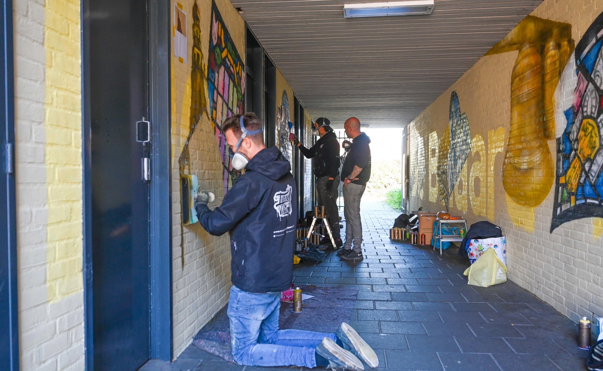 Paul Jongsma, Mitch Koningstein en Duane Tomala van Tunnel Vision leggen de laatste hand aan een graffitikunstwerk passage De Beiaard.