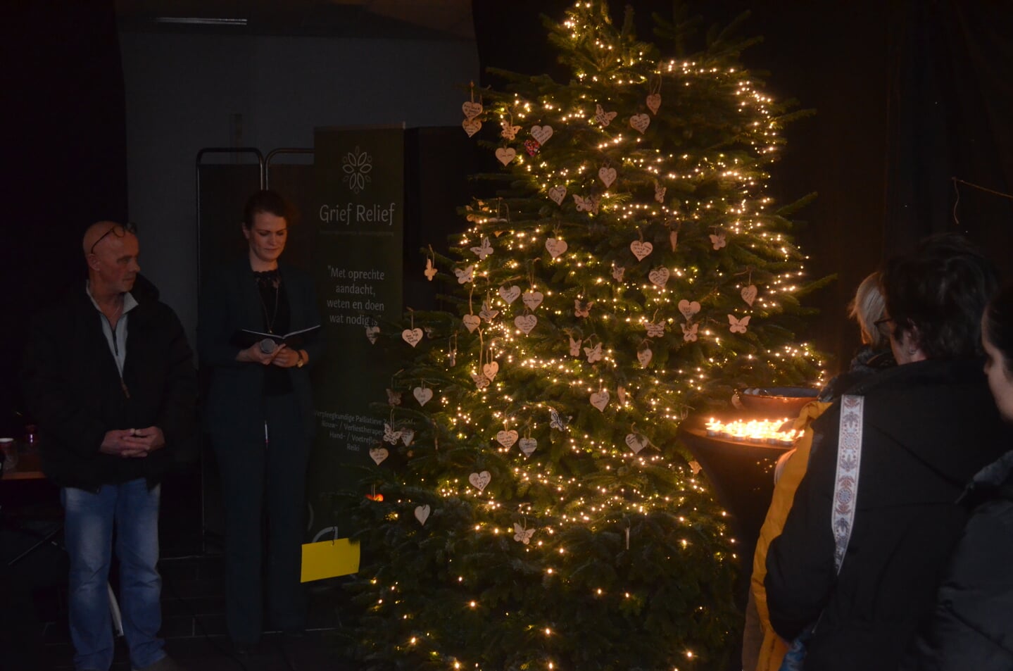 De namen van overleden dierbaren worden genoemd en de lichtjes in de kerstboom worden ontstoken.