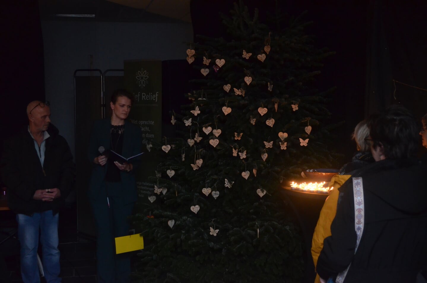 De namen van overleden dierbaren worden genoemd en de lichtjes in de kerstboom worden ontstoken.