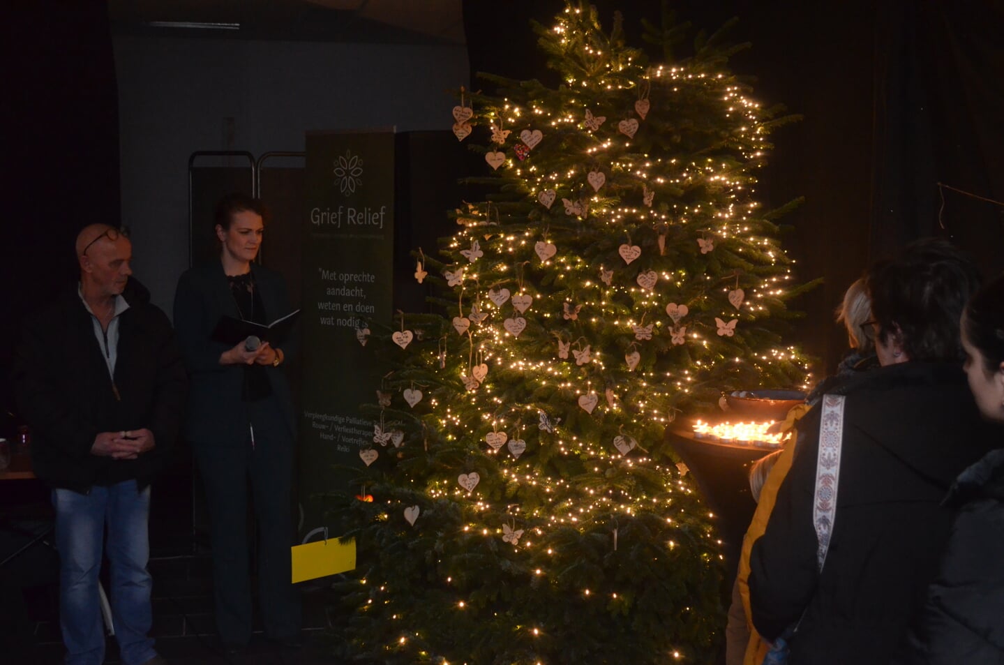 De namen van overleden dierbaren worden genoemd en de lichtjes in de kerstboom worden ontstoken.