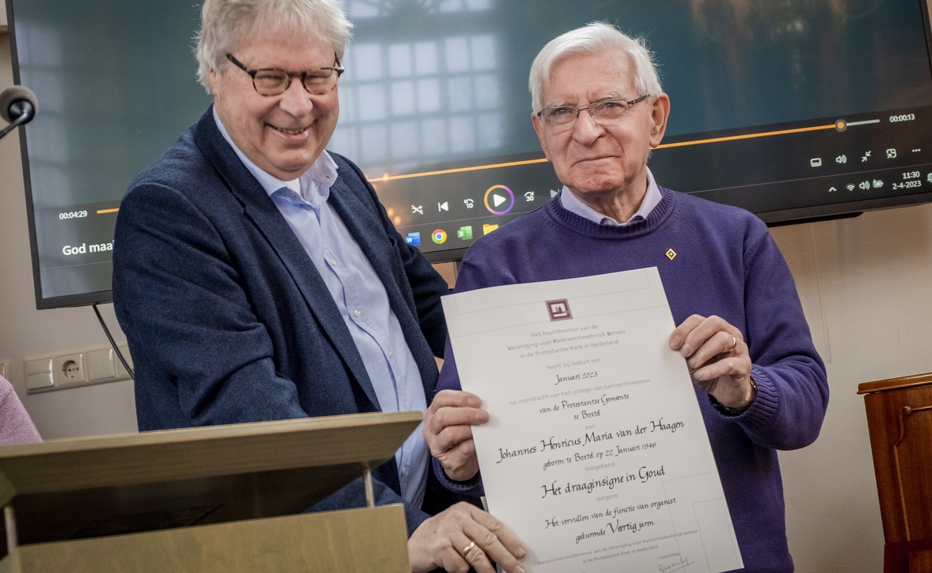 Uit handen van kerkrentmeester Pieter Springer ontving Hans van der Haagen (rechts) een gouden insigne omdat hij veertig jaar organist is in de protestantse kerk.
