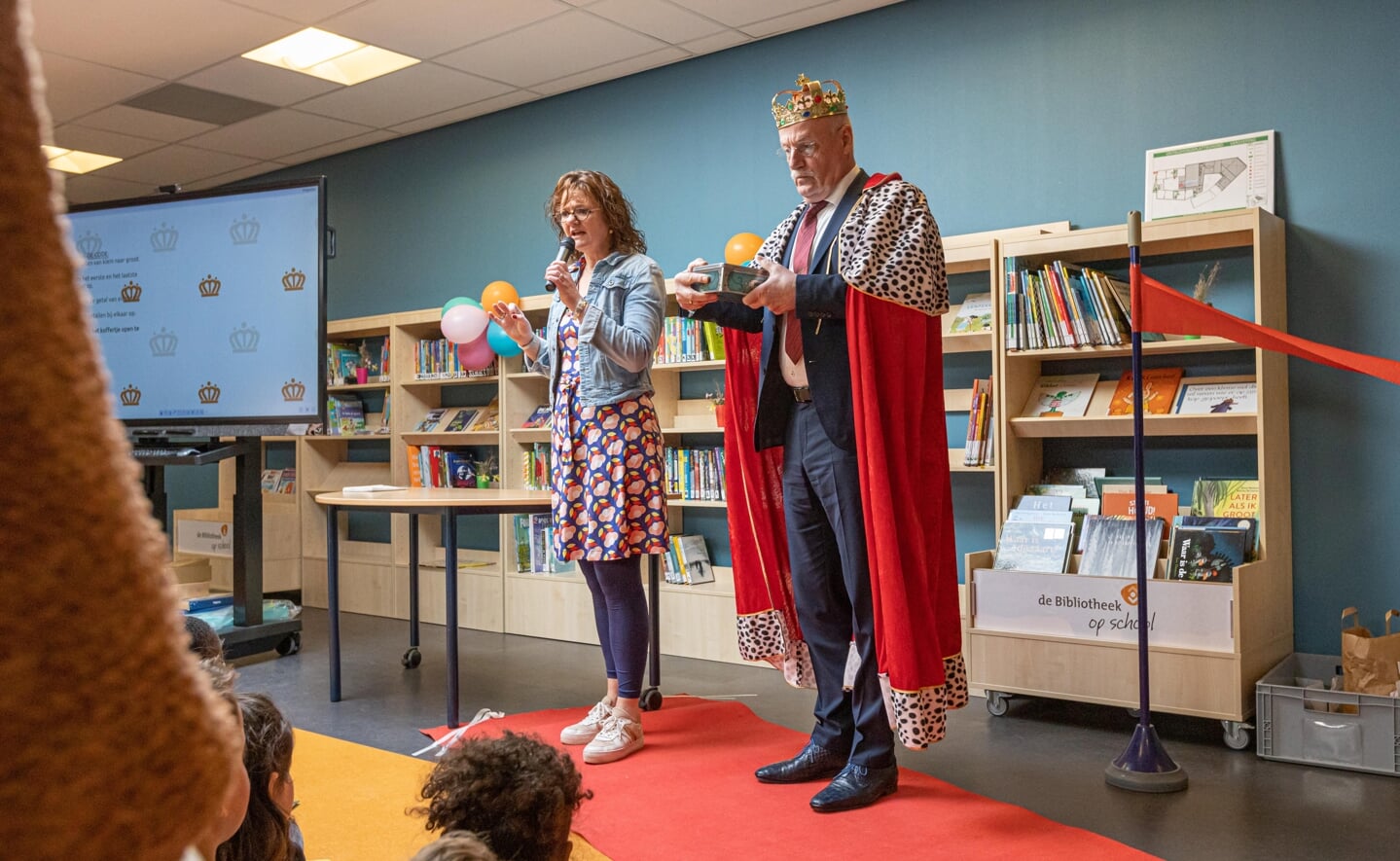 Niemand minder dan 'koning' Alexander Willem (natuurlijk niet de echte) opende dinsdagmiddag de nieuwe bibliotheek van de Prinses Amaliaschool. Docent Anke van Dijk (links) is de initiator van het boekenpunt op de basisschool.
