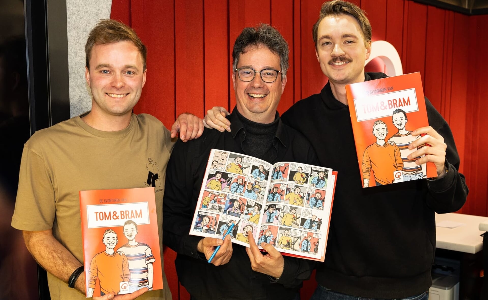 De Boxtelse striptekenaar Ralph Dikmans (midden) presenteerde vandaag het stripboek over Qmusic-sterren Tom van der Weerd (links) en Bram Krikke (rechts) tijdens de uitzending van het radio-duo.  
