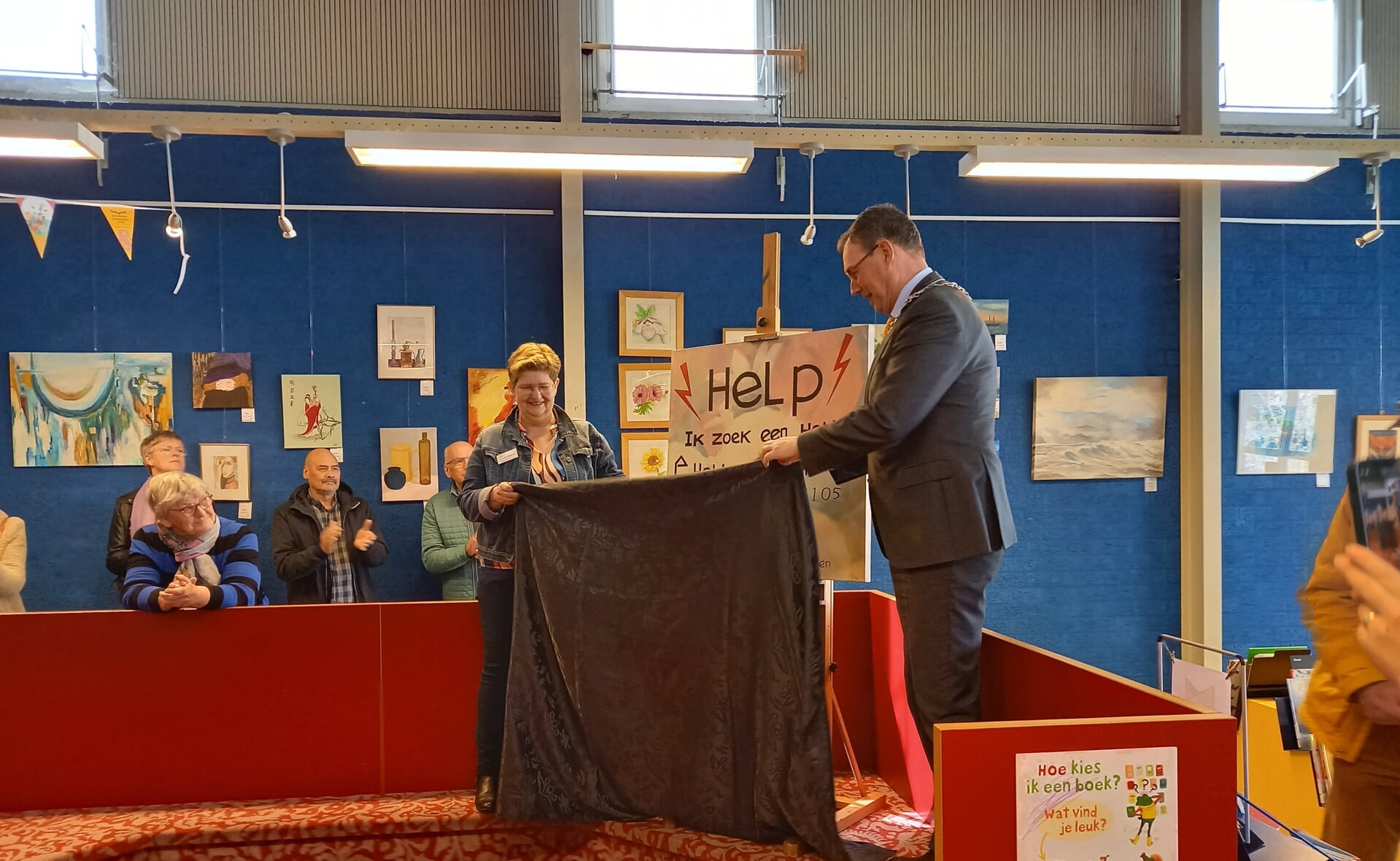 Jacqueline Thomassen en burgemeester Ronald van Meygaarden onthullen het bord met de tekst 'Help, ik zoek een hobby'.