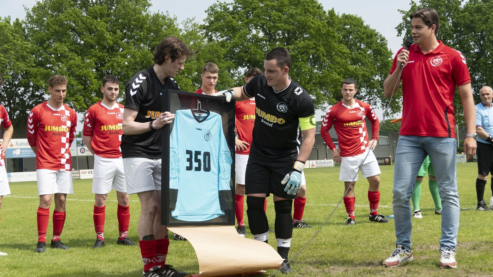 Keeper Raymon Strik (rechts) ontvangt een ingelijst shirt.