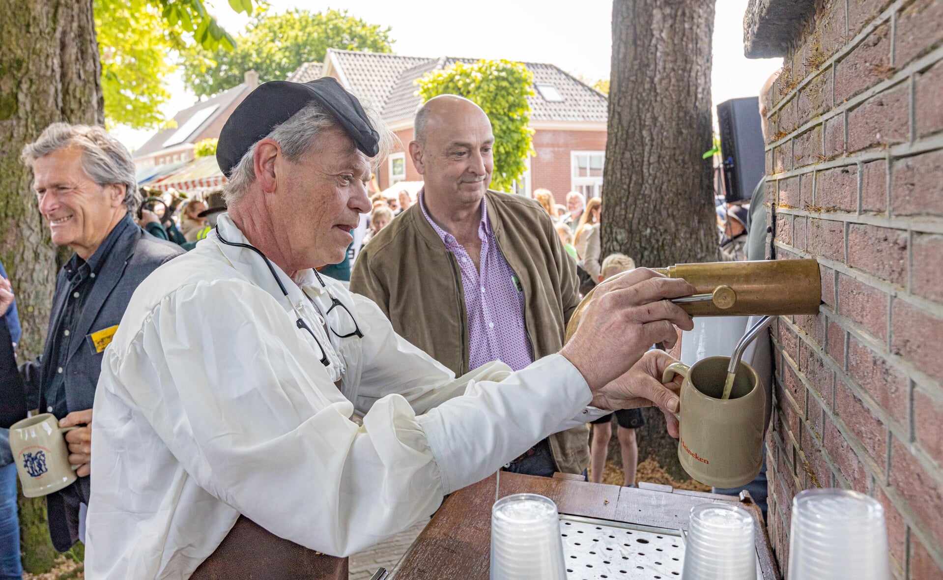 Tapper Gerard Pijnenburg laat het bier in de aardewerken pullen stromen.