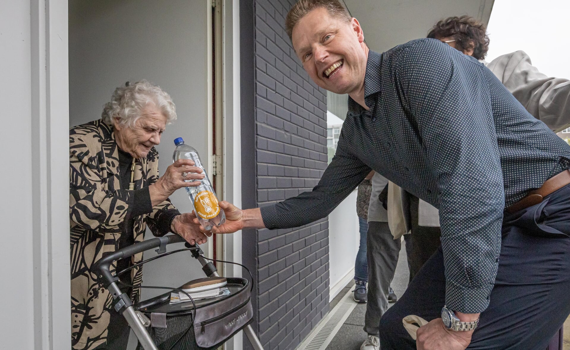 Wethouder Wim van der Zanden reikt het eerste flesje water uit aan Annie van der Sloot. (93)