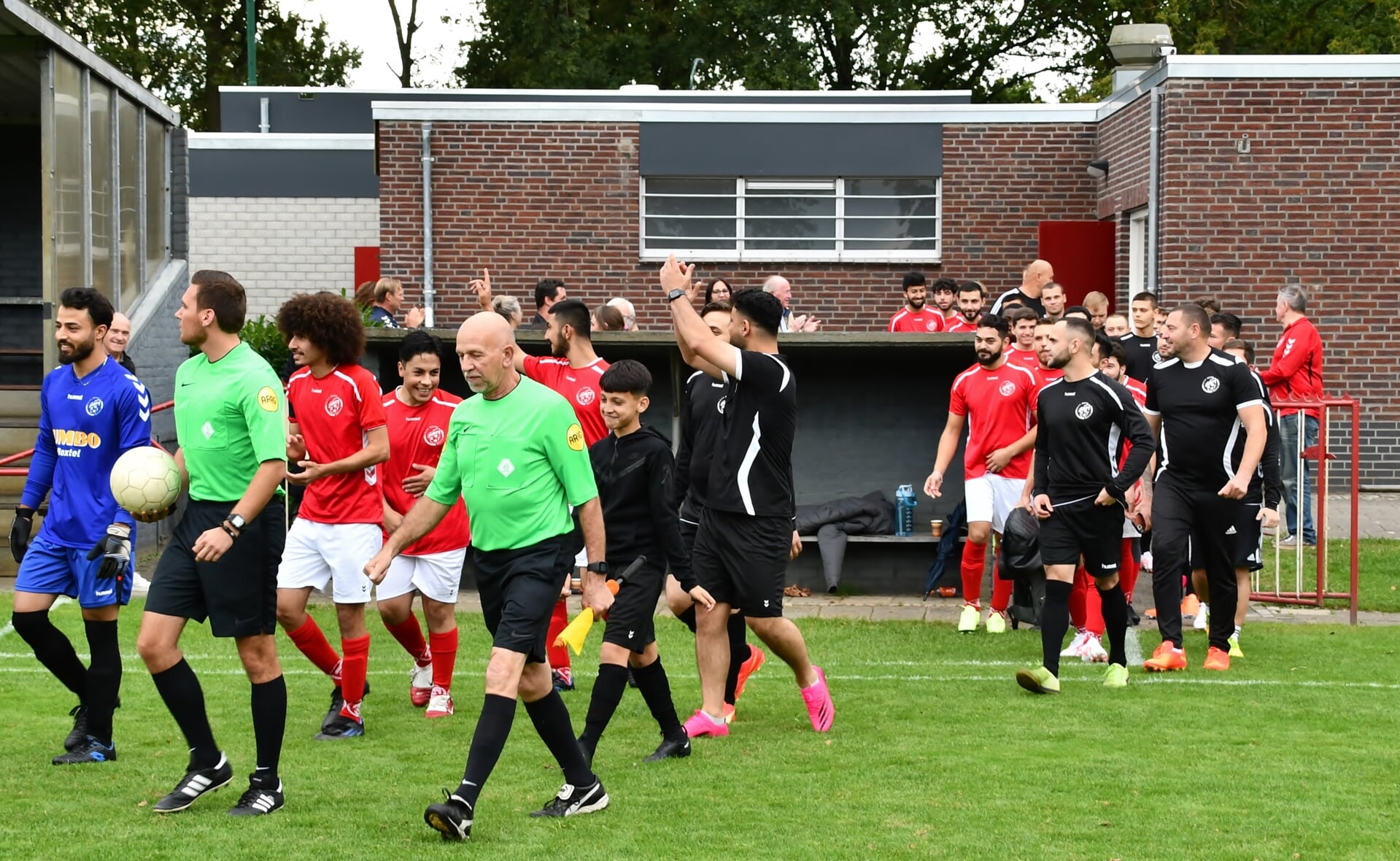 Spelers en arbiters komen het veld op voor de interland.