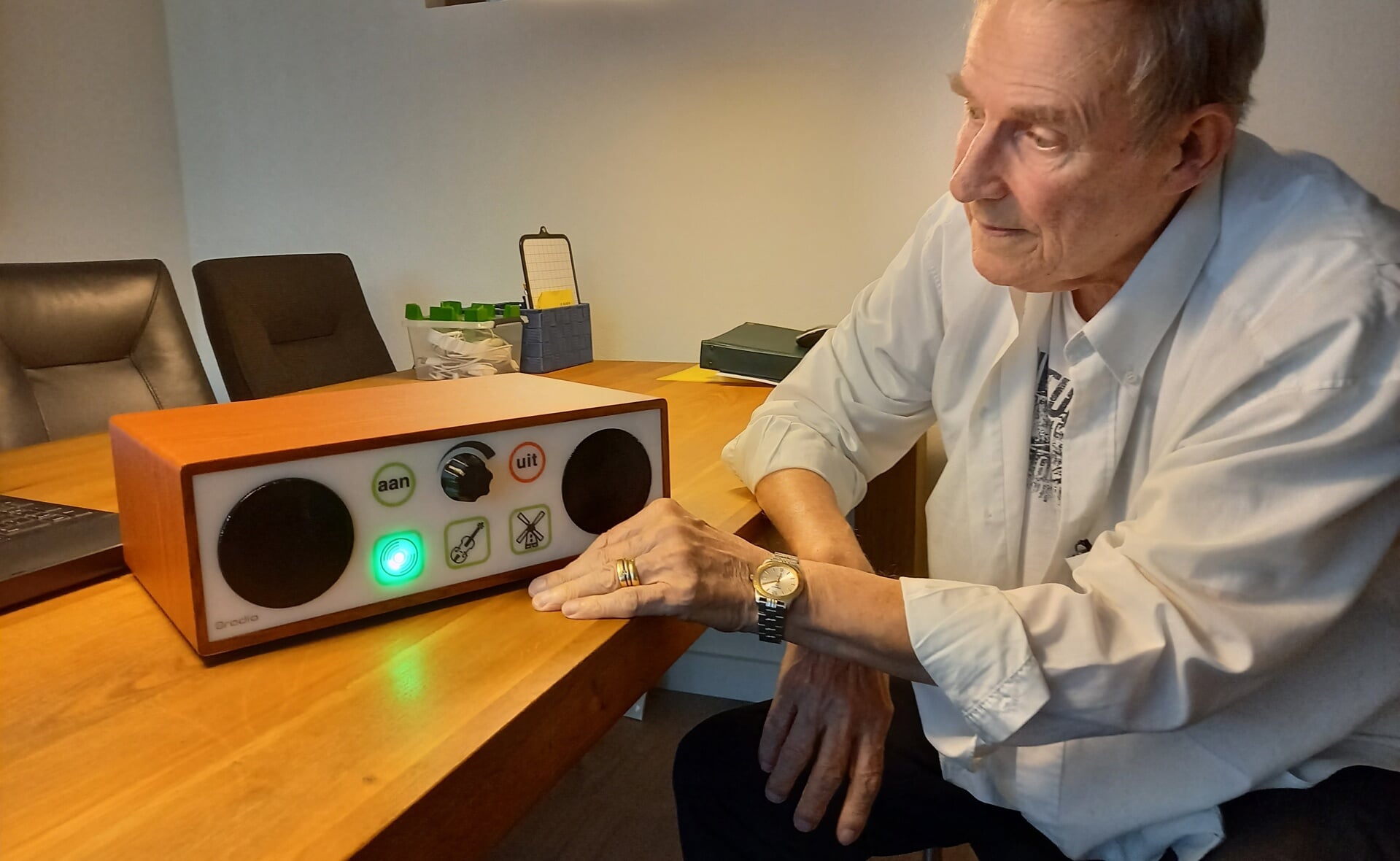 Martin Vos toont een Oradio. Het apparaat is eenvoudig te bedienen en dat is precies de kracht.