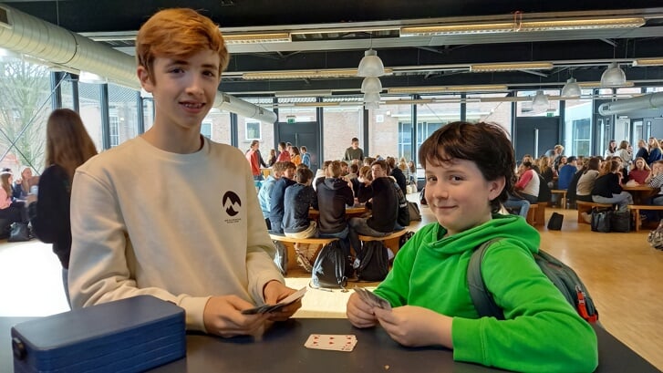 Samuel Queens (links) en Samuel Groenendaal kaarten graag in de pauze. En ze zijn niet de enige leerlingen die een spelletje spelen terwijl ze hun boterham opeten.