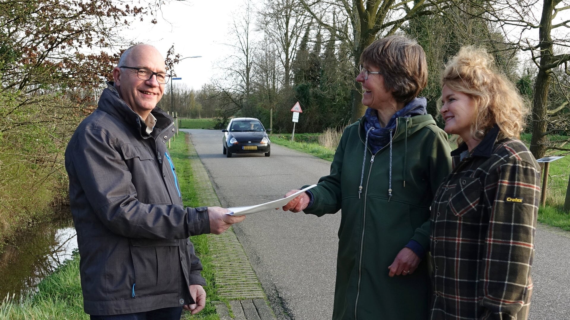 Wethouder Fred van Nistelrooij neemt de resultaten van de verkeersenquête in ontvangst uit handen Inger Klein (midden) en Sylvia Beerens.