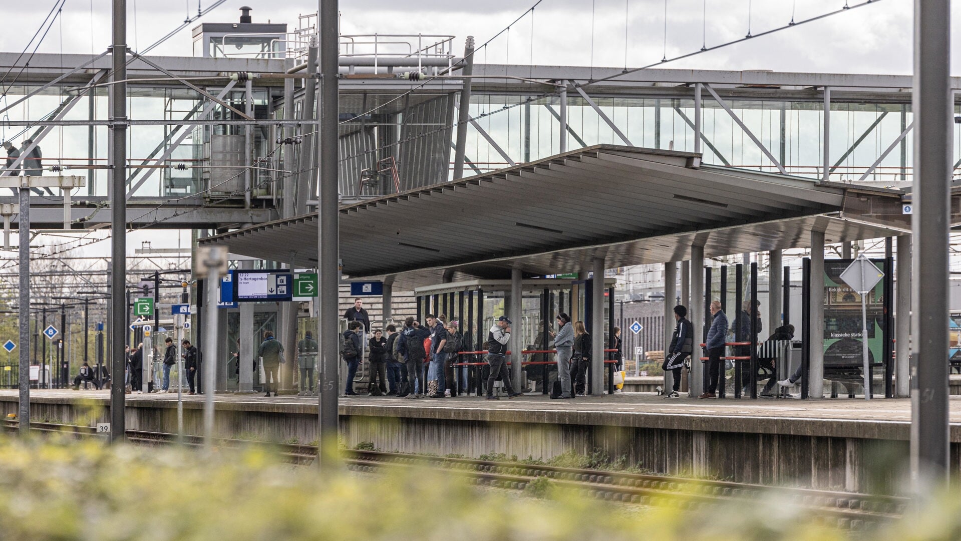 OV-reizigers wachten op het perron van het Boxtelse NS-station op hun vervoer. Dinsdagochtend reden er minder treinen wegens een defect aan het spoor. 