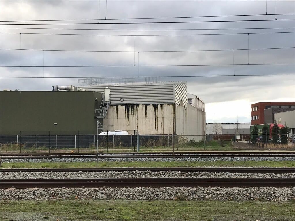 Op de betonnen buitenwand van een van de twee zuiveringsbassin zijn de natte plekken van de recente lekkage duidelijk zichtbaar. De foto is genomen vanaf de Parallelweg Zuid, aan de overkant van het spoor. (Foto: PvdA-GroenLinks).