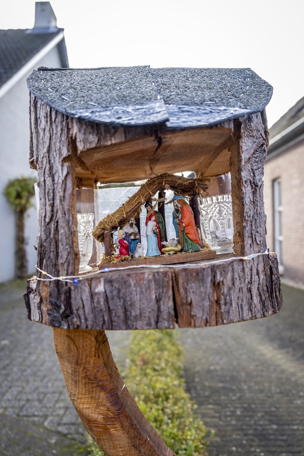 Ambachtswerk aan de Gasthuisstraat in Gemonde. De maker houwde het tussenstuk van een boomstam weg om het Bijbelse kersttafereel onderdak te bieden. 