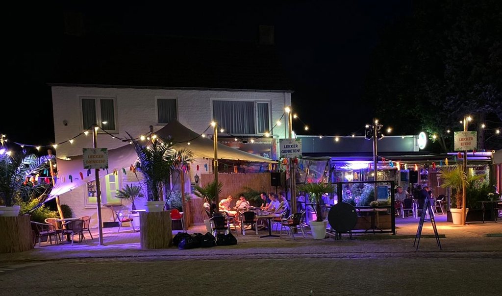 Het terras van Ons Café is zomers aangekleed met wuivende palmen en straalt vakantiegevoel uit. Uitbater Michel van de Sande zorgt met zijn activiteitenprogramma voor leven in de brouwerij. (Foto: Michel van de Sande).