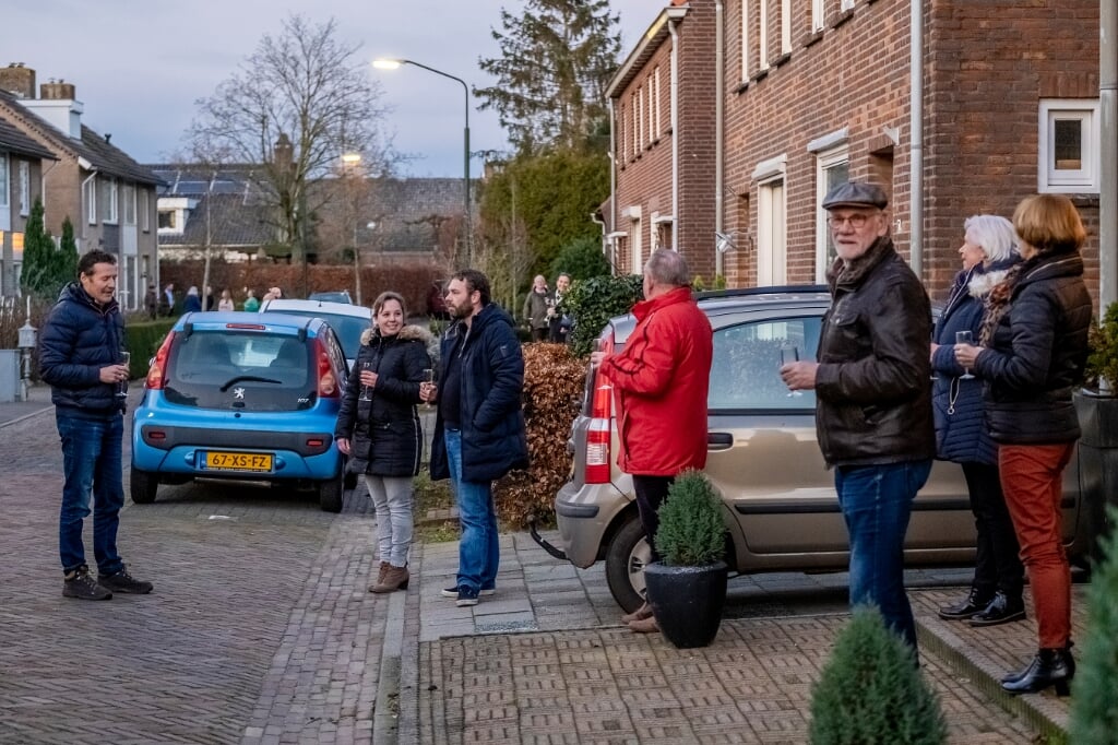 Bewoners van de Lochtenberg in Esch proosten vanaf hun voordeur met elkaar op het nieuwe jaar. (Foto: Peter de Koning).