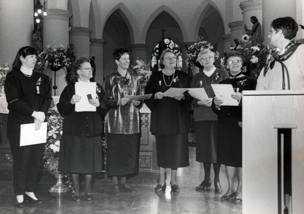De eerste zes vrouwelijke leden van het Sint-Petruskoor werden tijdens de jubileummis op 28 januari 1996 toegesproken door Riet Bevers (rechts) van het parochiebestuur. V.l.n.r. Lisette van Oirschot, Tineke Doedens, Marlies Spijkers, Betsie van Kessel, Trees Pijnenburg, en Jeannette van Breugel. (Archieffoto Brabants Centrum)