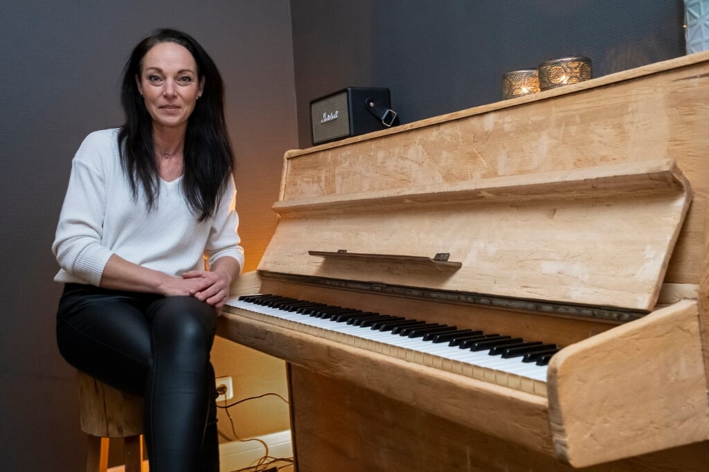 Saskia Vermaesen bij de piano die van haar zus was. Het instrument staat nu bij haar in de huiskamer. (Foto: Peter de Koning).