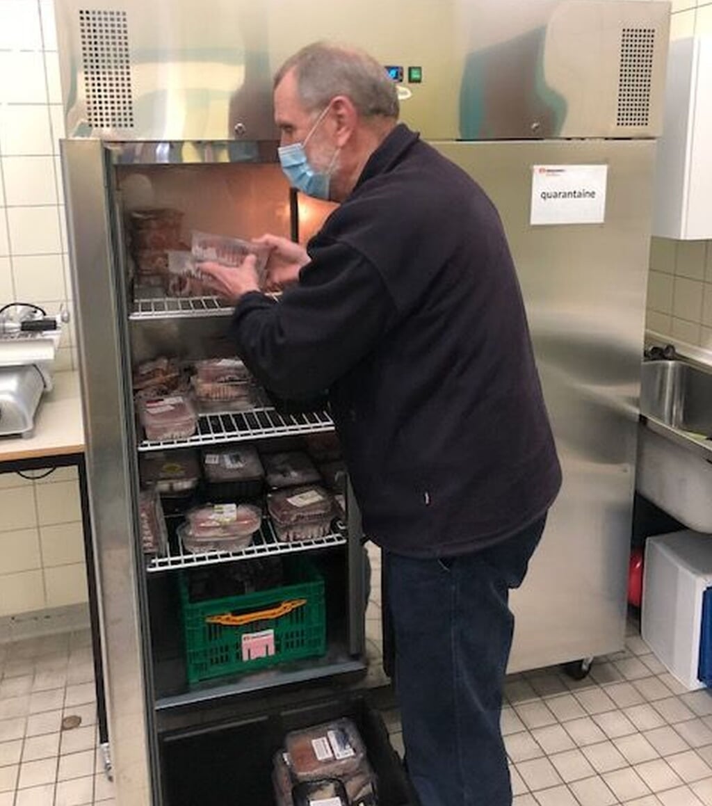 Vrijwilliger Hans Goossens legt vlees in de koeling van de voedselbank. (Foto: eigen collectie).