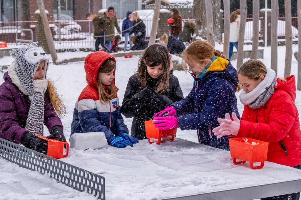 Alle leerlingen van de Angelaschool kregen maandagochtend een rode bak om sneeuwblokken te maken voor de bouw van een iglo. (Foto: Peter de Koning).