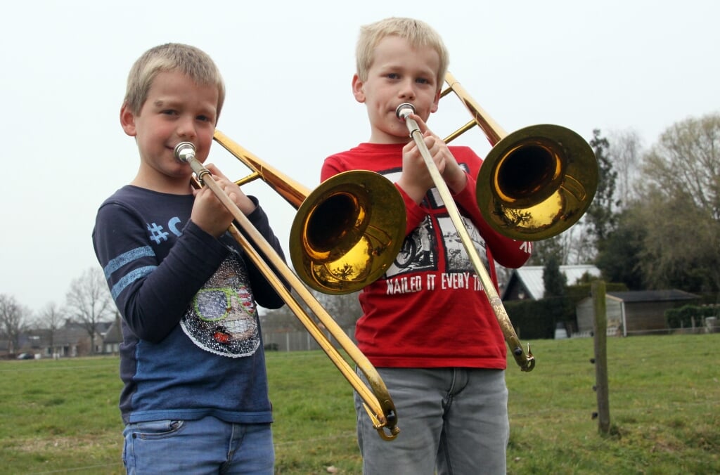 Jesper (11, rechts) en Otis (8) van Leeuwen spelen allebei trombone bij de Liempdse fanfare Concordia. De twee broers kunnen nu niet oefenen in thuishaven De Serenade, maar dat weerhoudt de jongens er niet van om toch te blazen.