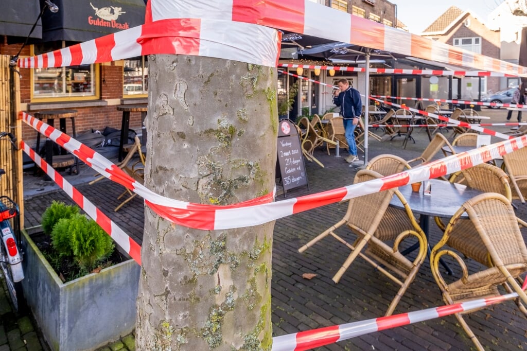 De terrassen van verschillende horecagelegenheden in Boxtel zijn afgezet met rood lint en voorzien van borden met een noodkreet. (Foto: Peter de Koning).