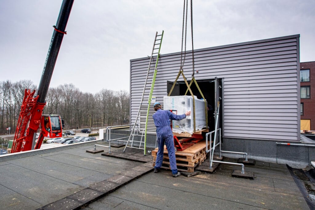 Met een grote kraan werden woensdagochtend de onderdelen van het nieuwe luchtbehandelingssysteem op het dak van de Boxtelse JBZ-locatie gehesen. (Foto: Bas van den Biggelaar).