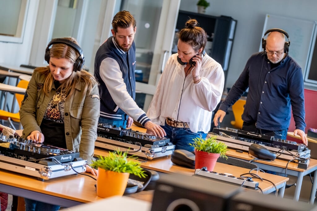 Jip van Krieken (tweede van links) geeft BHC-docenten van het Praktijkonderwijs aanwijzingen tijdens deejay-workshop. 