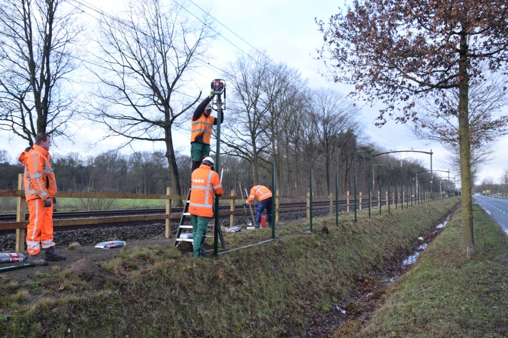 Werklui zijn sinds vorige week in opdracht van ProRail met het plaatsen van palen langs het spoor bij de Kapelweg. Het daadwerkelijke hek volgt later. (Foto: Rens van den Elsen).