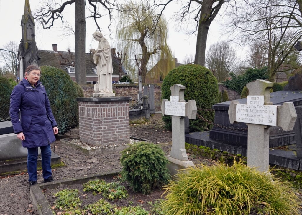 Ricky van Oorschot bij een van de graven van JMJ-zusters op het oude kerkhof van Gemonde. In het midden het beeld van Sint-Odulphus dat ooit de gevel van het vroegere klooster sierde. (Foto: Albert Stolwijk). 