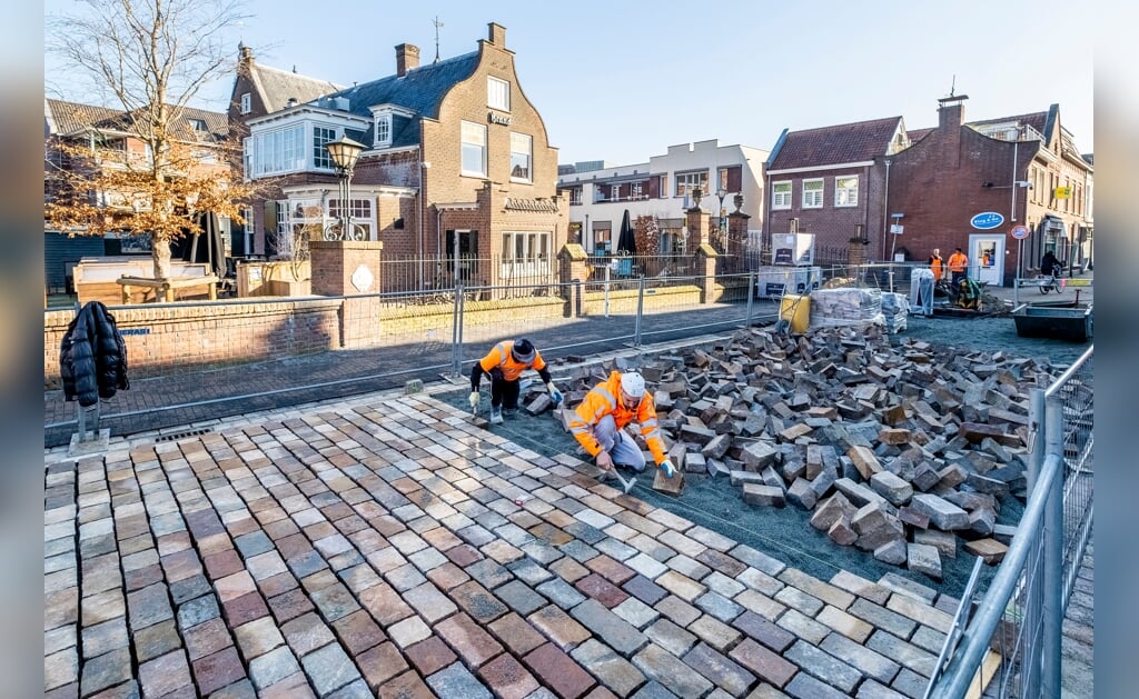 Stratenmakers van aannemingsbedrijf Heijmans aan het werk in de Rechterstraat. De Zwaanse Brug is al geplaveid met Italiaans natuursteen. (Foto: Peter de Koning).