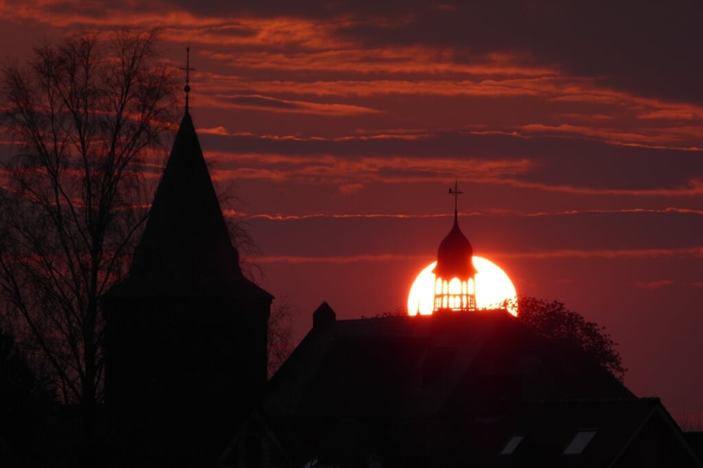 Chris Veen uit Boxtel fotografeerde maandagavond de zonsondergang bij de Sint-Willibrorduskerk in Esch. 