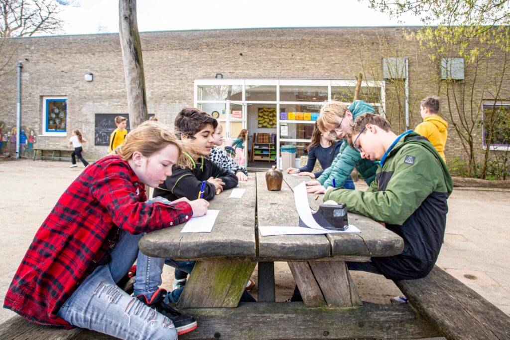 Leerlingen van de Molenwijkschool volgen buiten een actieve taalles. (Foto: Bas van den Biggelaar).