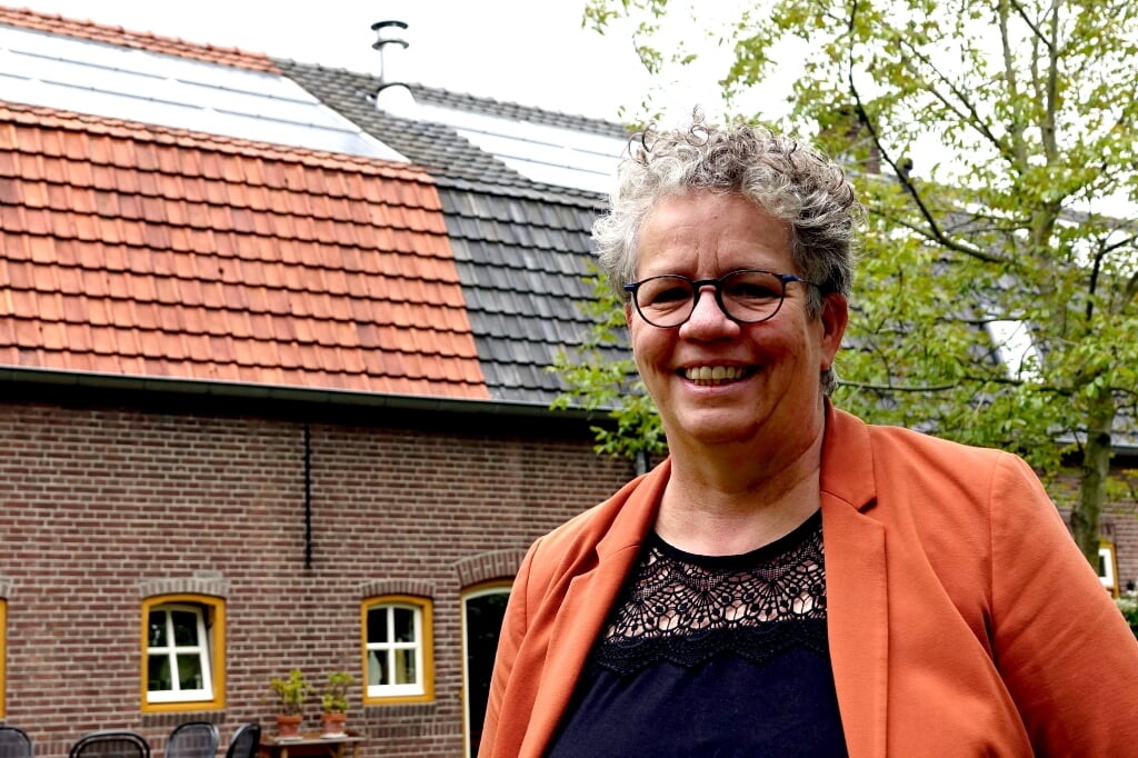 Wethouder Désiré van Laarhoven in de achtertuin van haar woning in Liempde. In de woonboerderij zijn de zonnepanelen ingebouwd in het dak. (Foto: Gerard Schalkx).