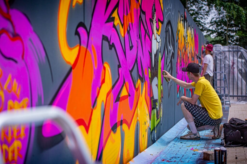 Een grijze afscheiding tussen twee bedrijfspanden werd zaterdag door graffitikunstenaars van Tunnel Vision Boxtel omgetoverd tot een kleurrijk kunstwerk. 