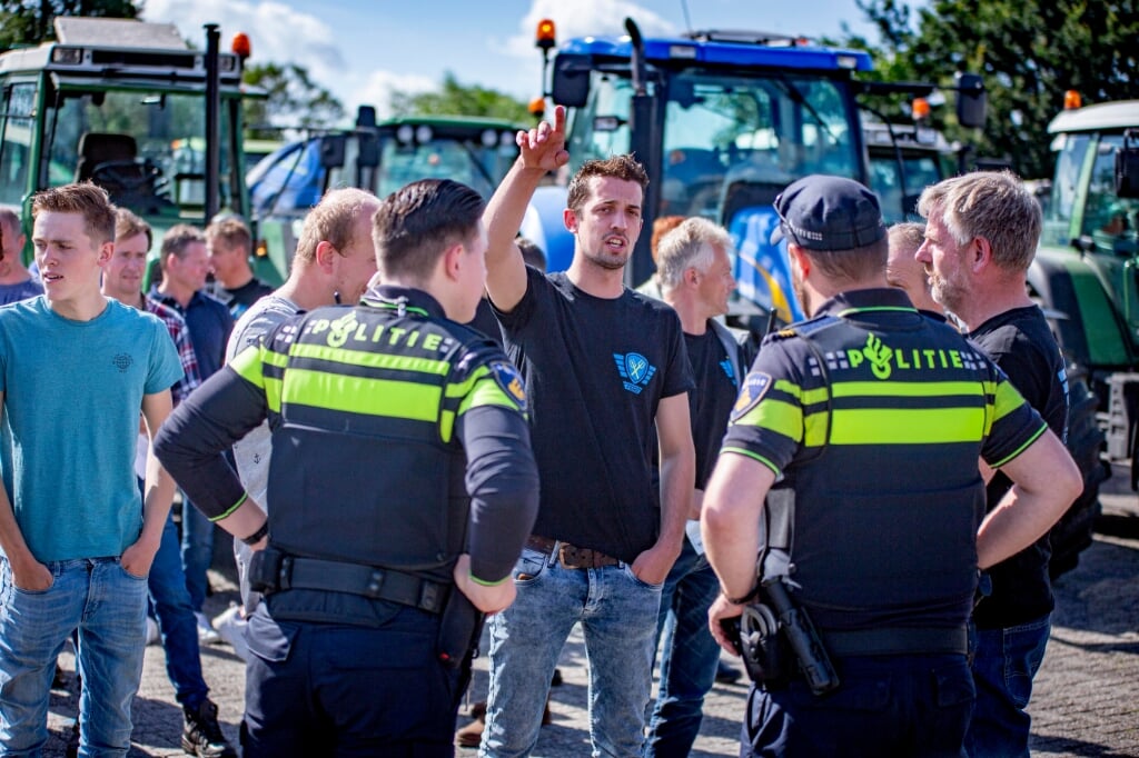 Stan Verhoeven overlegt met de politie over het vertrek van de stoet tractoren.