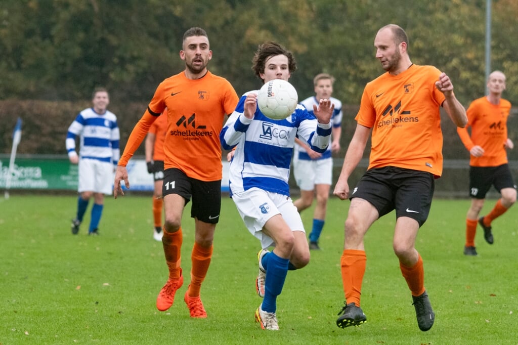 Willem Heijnen van Essche Boys probeert tussen twee steviger tegenstanders door te rennen. Heijnen maakte een van de vier doelpunten voor zijn team.