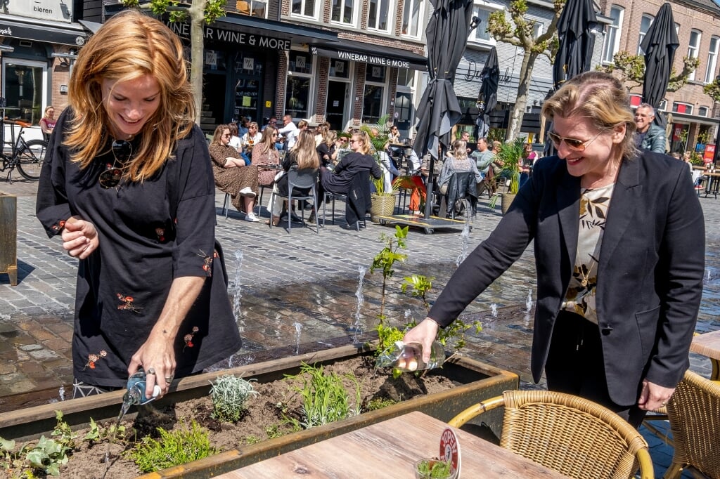 Claire Wijnstok (links) en wethouder Mariëlle van Alphen gaven vorig jaar de plantjes water, toen de bakken er net stonden.