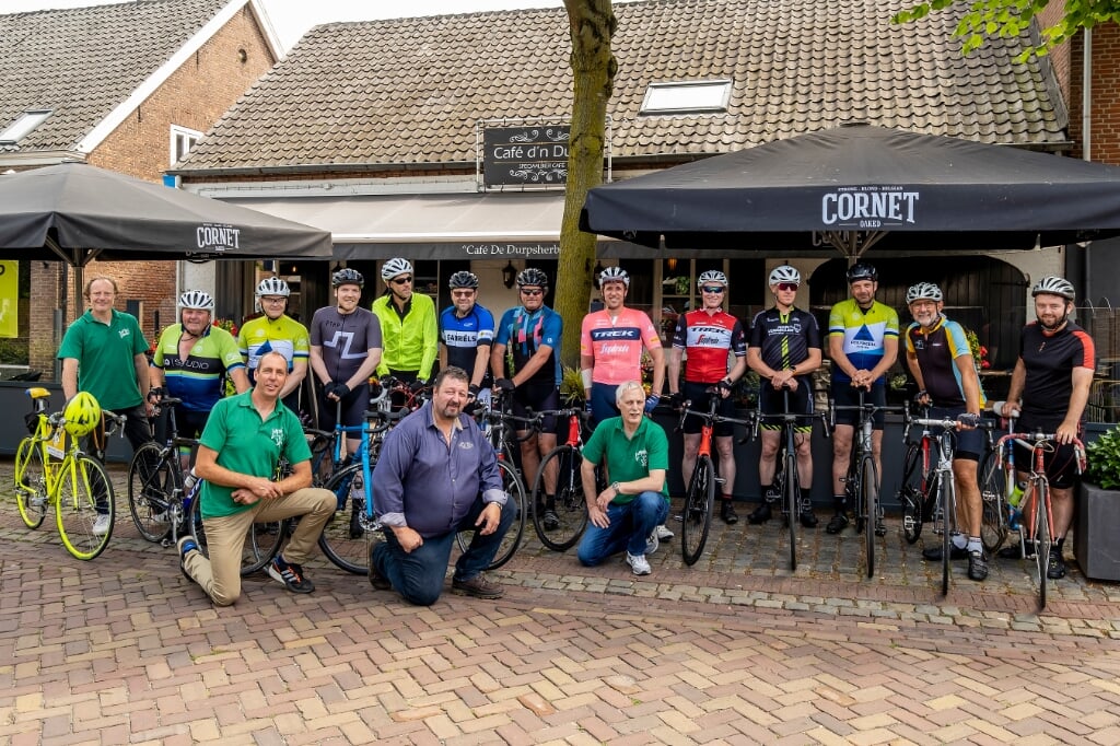 De prijswinnaars van het Tourspel Liempde 2021 poseren met Koen de Kort (midden), de organisatoren en kastelein Ton van Alphen voor café De Durpsherberg.