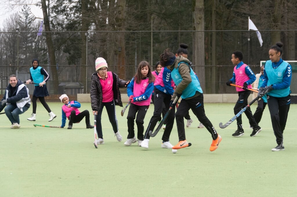 Jonge vluchtelingen maken plezier op een hockeyveld van MEP. Ze wilden wel vaker hockeyen, gaven ze na de clinic aan.