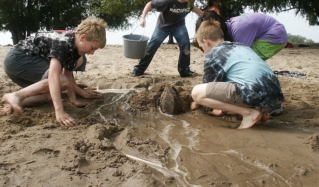 Kinderen aan de slag met zand en klei.