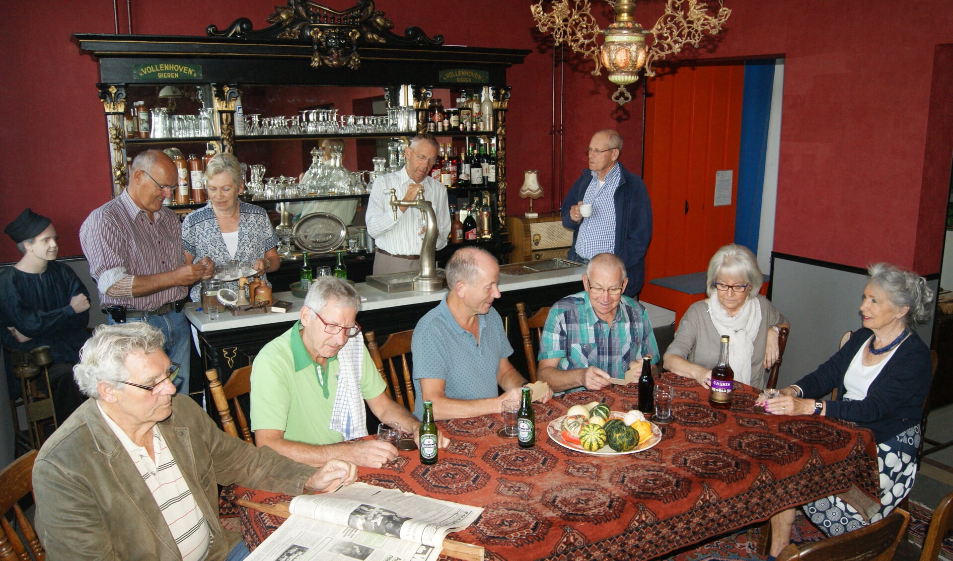 Een deel van de vrijwilligers die hebben bijgedragen aan de totstandkoming van het museumcafé poseren voor de historische tapkast
